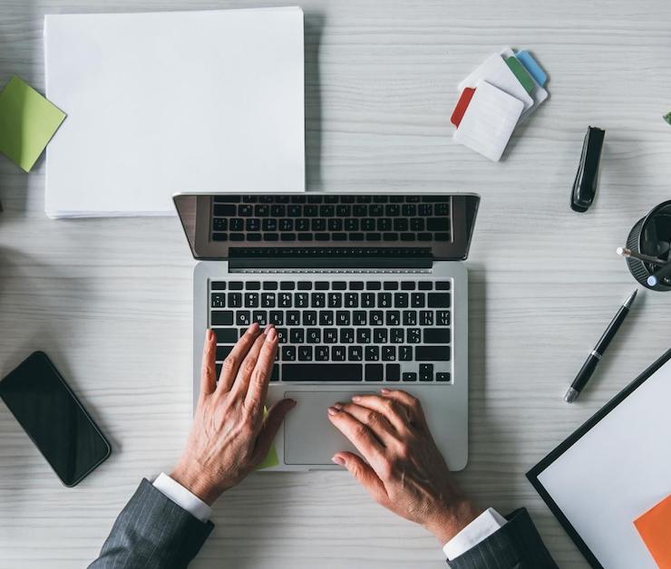 laptop and two hands typing