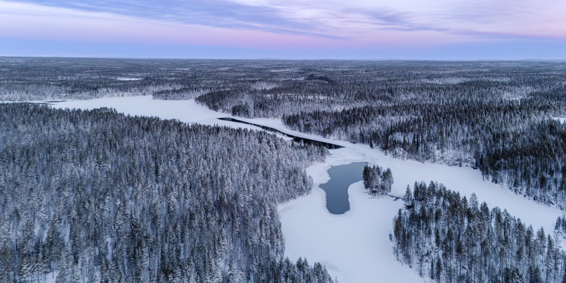 winter landscape of a forest and a lake covered in snow